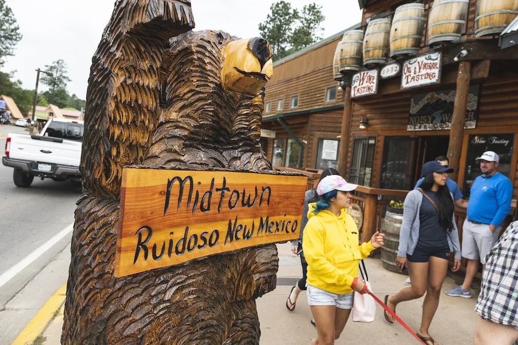 Visitors walking near one of Ruidoso's carved bear sculptures
