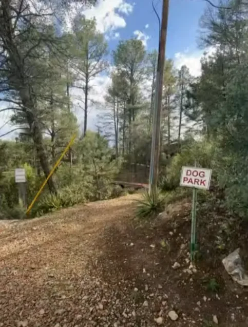 Gravel path to the dog park with a red and white Dog Park sign