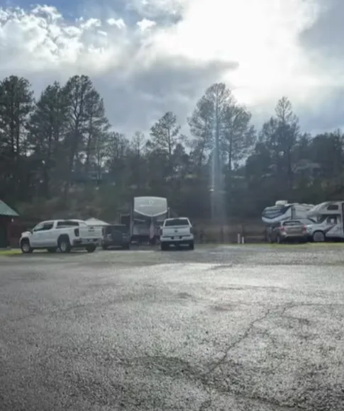 Wet gravel lot with trucks and RVs after rain