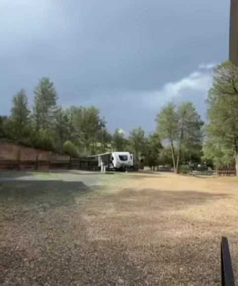 White travel trailer parked on gravel under a cloudy sky